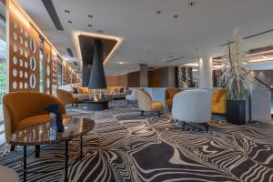 a lobby with couches and tables and chairs at Rivage Hôtel & Spa Annecy in Annecy