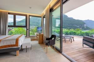 a bedroom with a bed and a balcony with mountains at Rivage Hôtel & Spa Annecy in Annecy