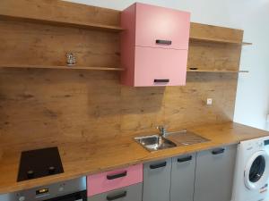 a kitchen with a sink and a pink cabinet at Apartments Katica in Rab +4 photos
