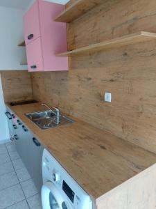 a kitchen with a sink and a washing machine at Apartments Katica in Rab