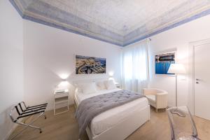 a bedroom with a bed and a table and a chair at La Home42 Suite in Palermo