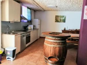 a kitchen with a wooden barrel in the middle at Apartamentos Turísticos San Breixo in Carballo