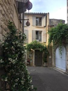 un vicolo con un edificio e un edificio con balcone di Le Lapin Blanc a Saint-Rémy-de-Provence