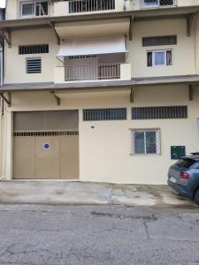 a building with two garage doors and a car parked in front at Hello Guyane - Studio 5, Haut Standing in Cayenne