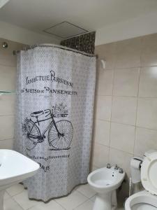 ein Bad mit einem Duschvorhang mit einem Fahrrad darauf in der Unterkunft Apart Ocampo Catamarca II in San Fernando del Valle de Catamarca