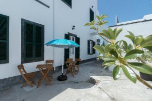 a patio with two chairs and an umbrella at Lagoa Hostel & Suites in Lagoa