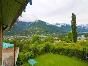 Vistas a una ciudad con montañas en el fondo en The Byke Neelkanth Manali, en Nagar