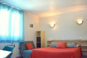 1 dormitorio con cama, sofá y ventana en Chambres d'Hôtes L'Orée des Bois, en Lacrouzette
