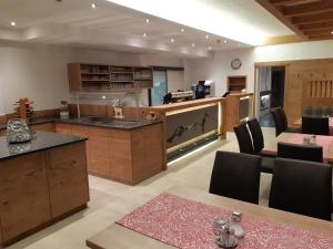 a large kitchen with wooden cabinets and a table with chairs at Gästehaus Bräuer in Neukirchen am Großvenediger +21 photos