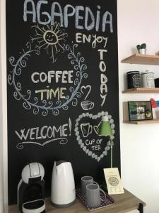 una pared de pizarra con una señal de tiempo para el café. en Cozy Room AGAPEDIA en Brasov