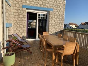 a wooden table and chairs on a deck at La Villa L'Escale in Audresselles
