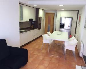 a kitchen with a white table and white chairs at Apartment - 2 Bedrooms - 02447 in Malpica