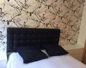 a bedroom with a black headboard with a tree mural at Apartment - 2 Bedrooms - 02447 in Malpica