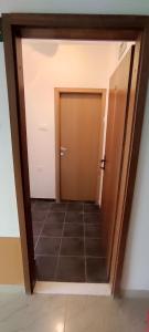 a hallway with a door and a tile floor at Ap Nada in Rogoznica