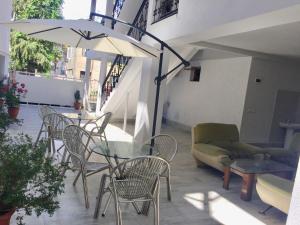 a patio with a glass table and chairs and an umbrella at Katrin in K'obulet'i