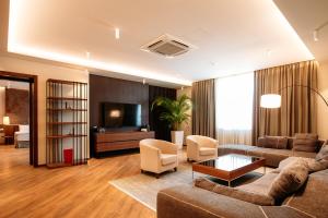 a living room with a couch and a tv at Hotel Tbilisi Tower in Tbilisi City