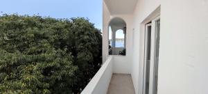 a hallway of a white building with a window and trees at Ap Nada in Rogoznica