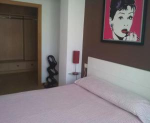 1 dormitorio con 1 cama y una pintura en la pared en Apartment - 3 Bedrooms with WiFi - 02597, en A Coruña