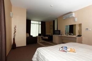 um quarto de hotel com uma cama e uma sala de estar em Evridika Hotel em Devin