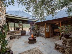 an outdoor patio with a fireplace in a log cabin at De Cango Farm in Oudtshoorn