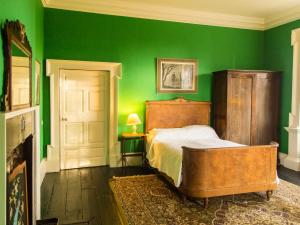 a green bedroom with a bed and a green wall at Roundwood House in Mountrath