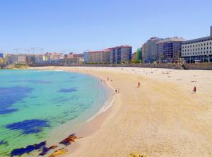 una playa con gente y el océano y edificios en Apartment - 3 Bedrooms with WiFi - 02597, en A Coruña