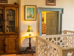 a room with a staircase and a lamp on a table at Roundwood House in Mountrath