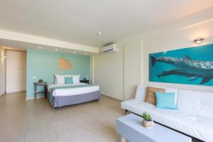 a hotel room with a bed and a couch at Dolphin Suites & Wellness Curacao in Willemstad