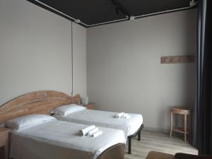 2 letti in una camera con pareti bianche di Le Coltie - affittacamere e appartamenti a Venturina Terme