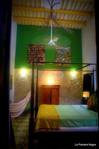 a bedroom with a bed and a green wall at La Pantera Negra in Mérida