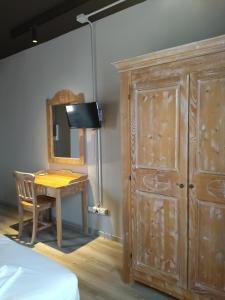 a bedroom with a wooden cabinet and a table with a mirror at Le Coltie - affittacamere e appartamenti in Venturina Terme