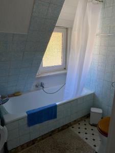 La salle de bains est pourvue d'une baignoire et d'une fenêtre. dans l'établissement Ferienwohnung Meilerplatz – Familienfreundliche Ferienwohnung für max. 4 Personen in Bad Lauterberg am Harz, à Bad Lauterberg