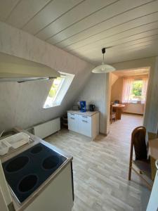 a kitchen with a stove top oven in a room at Ferienwohnung Meilerplatz – Familienfreundliche Ferienwohnung für max. 4 Personen in Bad Lauterberg am Harz in Bad Lauterberg