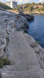 a stone path leading to the water on a cliff at Residencia Santiago Mallorca in Cala Figuera