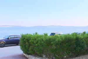 twee auto's geparkeerd op een parkeerplaats naast het water bij Les Baux 1 in Sanary-sur-Mer