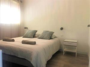 een slaapkamer met een bed met 2 kussens erop bij Les Baux 1 in Sanary-sur-Mer