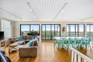 uma sala de estar com um sofá, uma mesa e cadeiras em Robbins Rest Retreat em Ocean Beach