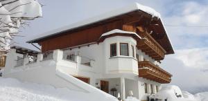 una casa coperta di neve di fronte di Haus Anna Ein Haus mit Herz a Fliess