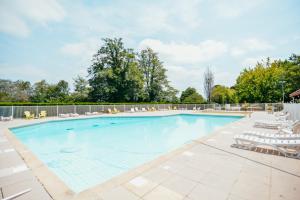 a swimming pool with chaise lounge chairs and a volleyquet at Cocooning Tipi - Seignosse in Seignosse