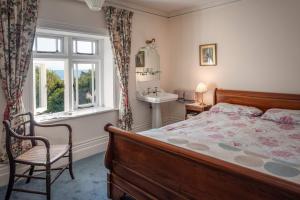 a bedroom with a bed and a sink and a window at Lisle Combe in Ventnor