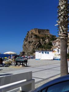 a view of a beach with a castle on a hill at LA RAJA in Scilla