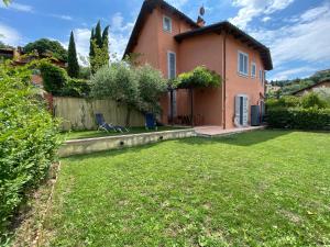 a house with a green yard in front of it at La casetta nel giardino in Cetona