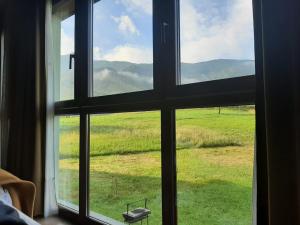 una ventana con vistas a un campo de césped en Vivienda vacacional La Poza la Braña, en Llanes