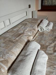 łóżko z dwoma ręcznikami na górze w obiekcie Vite diPinte 1 bilocale in langa w mieście Novello
