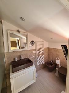 a bathroom with a sink and a toilet and a mirror at L'Isola nel Parco Boutique Rooms & Apartments in La Maddalena