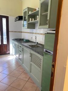 een keuken met groene kasten en een wastafel bij Affittacamere La Torre di Montalcino in Montalcino