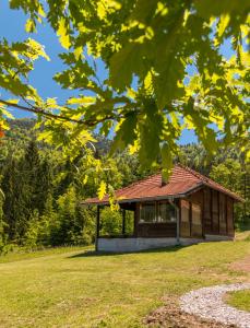 a small building in a field with trees in the background at Bogu iza nogu 1 in Rastište
