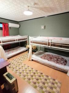 a room with three bunk beds and a rug at 静かに過ごす古民家ステイ Staying quietly in renovated house in Takashima