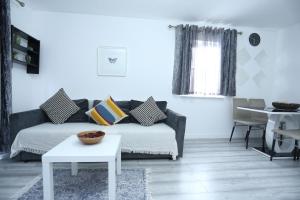 a living room with a couch and a table at Modern 2 Bedroom Flat, with Free Parking, and WIFI in Thamesmead