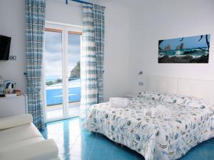 a bedroom with a bed and a view of the ocean at CapriOnda in Capri